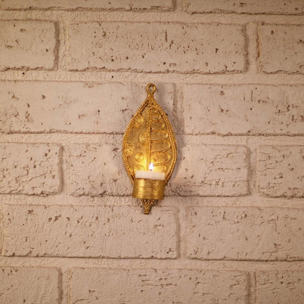 Two handmade Dhokra metal leaf-shaped tealight holders, crafted with intricate details